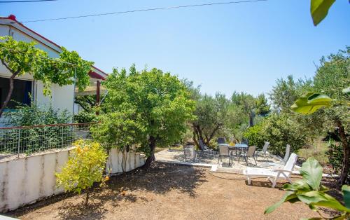 a garden with a table and chairs and trees at Haus Manya in Lassy in Lassi