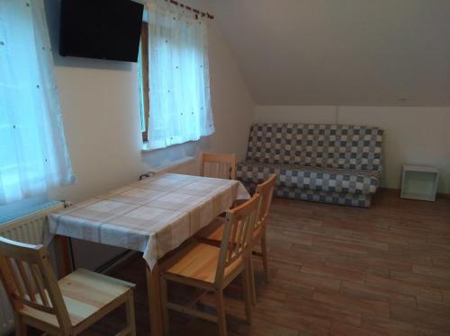 a dining room with a table and chairs and a couch at Apartment Sela in Tolmin