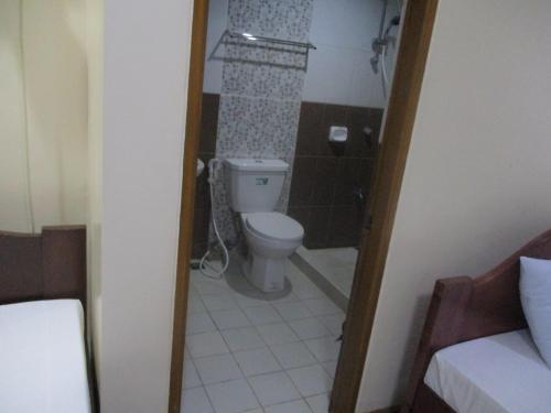 a small bathroom with a toilet and a shower at WMV Hotel & Restaurant in Infanta