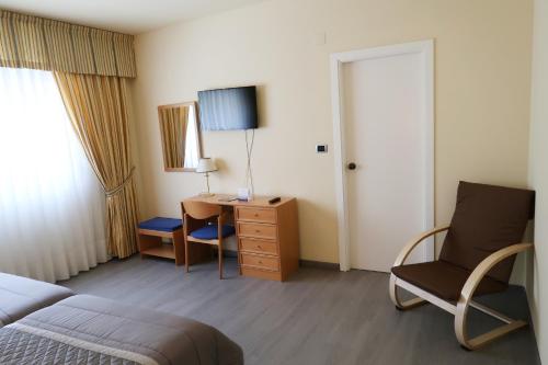a bedroom with a bed and a desk and a chair at Hotel O Camiño in O Barco de Valdeorras