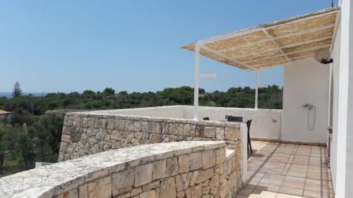 a stone wall next to a building at La stanza del paradiso in Torre Pali 