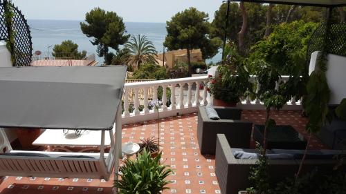 マラガにあるLuxury Sea Home&Terraceの白い手すりと椅子、植物のあるバルコニー