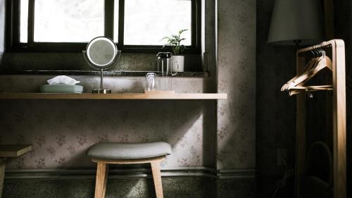 a stool in a bathroom with a mirror and a sink at Civil Life Tainan in Tainan