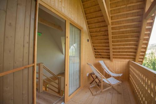 a porch with a chair and a sliding glass door at Magnolia Resort Chalets in Vişeu de Sus