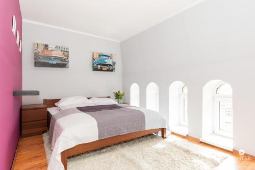 コウォブジェクにあるJantar Apartamenty - Loft u Aktoraのベッドルーム1室(ベッド1台、窓2つ付)