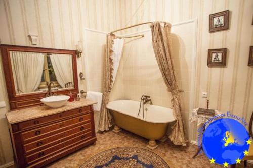 a bathroom with a tub and a sink and a mirror at Pakruojis Manor's Palace Boutique Hotel in Pakruojis