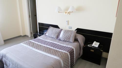 a bedroom with a large bed with purple pillows at Hotel O Camiño in O Barco de Valdeorras