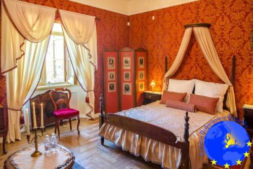 a bedroom with a large bed and a table at Pakruojis Manor's Palace Boutique Hotel in Pakruojis