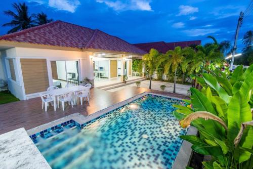 a villa with a swimming pool and a dining area at The Legacy Huahin Pool Villa in Hua Hin