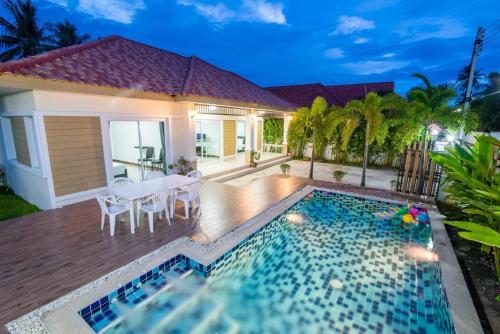 a backyard with a swimming pool and a house at The Legacy Huahin Pool Villa in Hua Hin