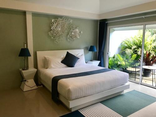 a bedroom with a bed and a large window at Purin Resort & Restaurant- SHA Plus in Had Yao Beach