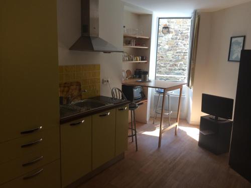 une petite cuisine avec un évier et une table dans l'établissement Studio Centre Granville, à Granville