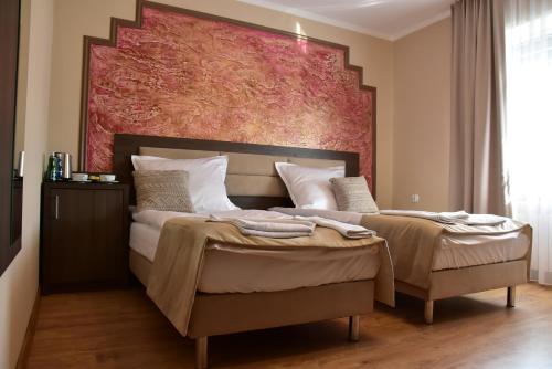a bedroom with a bed with a large painting on the wall at Pokoje Gościnne Lech in Strzałkowo