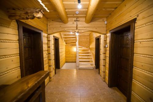 a hallway of a wooden cabin with stairs in it at Zbojnicky penzion in Oravska Jasenica