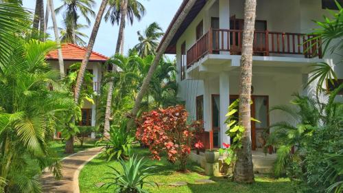 坦加拉的住宿－Good Karma，棕榈树的房子和通往房子的小径