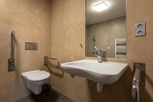a bathroom with a sink and a toilet at Hotel Grand in Čáslav