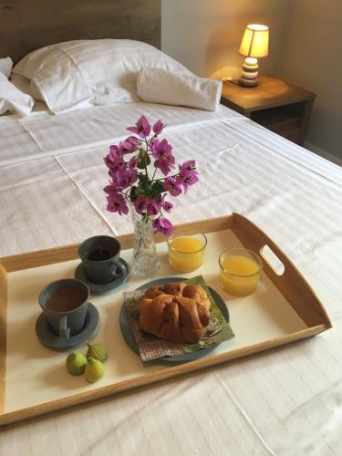a tray with food and flowers on a bed at Bed & Breakfast Kurtic in Supetar