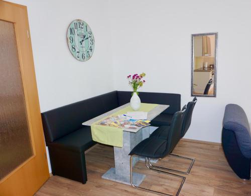 comedor con mesa, sillas y reloj en Manitius 9, DD-Friedrichstadt (Zentrumsnah) en Dresden