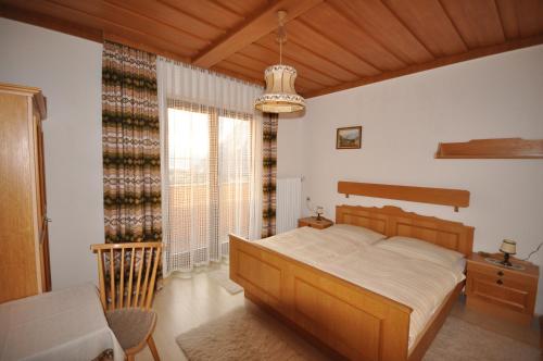 a bedroom with a wooden bed and a window at Appartement Kristall in Tauplitz