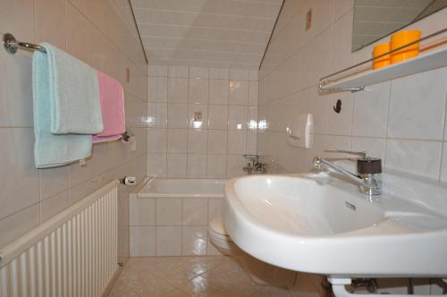 a white bathroom with a sink and a toilet at Appartement Kristall in Tauplitz