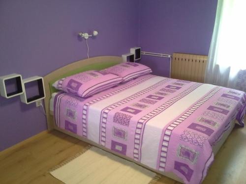 a bed with a pink and white blanket on it at K21 Apartment in Bovec