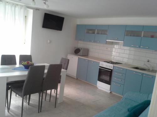eine Küche mit blauen Schränken sowie einem Tisch und Stühlen in der Unterkunft K21 Apartment in Bovec