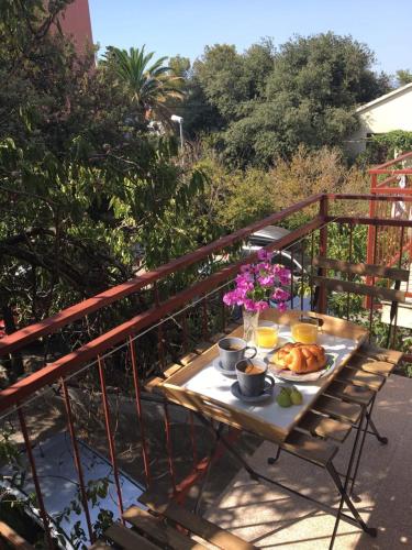 a table with a plate of food on a balcony at Bed & Breakfast Kurtic in Supetar