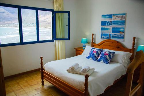カレタ・デ・ファマラにあるSeaview Risco de Famara 1のベッドルーム1室(スリッパ2枚付)
