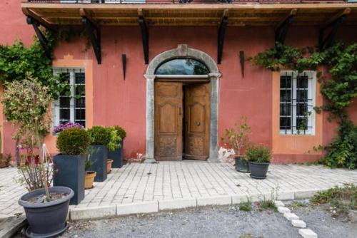 a red building with a wooden door in front at charme et standing centre ville in Barcelonnette