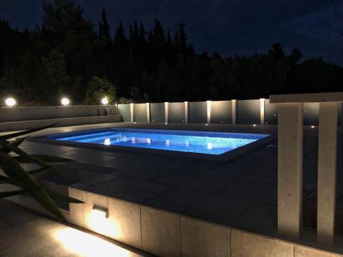 a swimming pool with lights in a backyard at night at Paradise in Brbinj