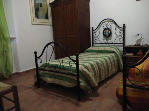 a bedroom with a bed and a wooden cabinet at Agriturismo Uliveto Gretacci in Montemerano