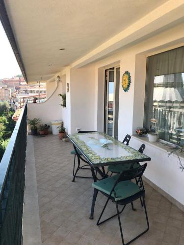 a patio with a table and chairs on a balcony at Atticus Apartment in Giardini Naxos