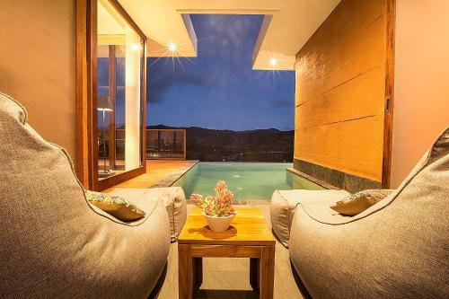 a living room with two chairs and a swimming pool at Seven Havens Residence in Selong Belanak