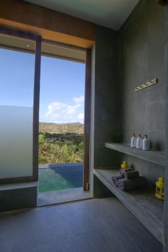 a room with a large glass door with a view at Seven Havens Residence in Selong Belanak