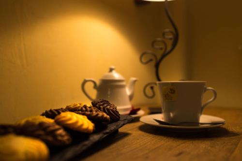 a table with a plate of donuts and a cup of coffee at Hotel Meublé Mon Rêve in Breuil-Cervinia