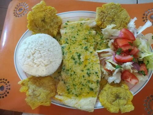 a plate of food with rice and other food items at Hosteria Cumilinche in Same