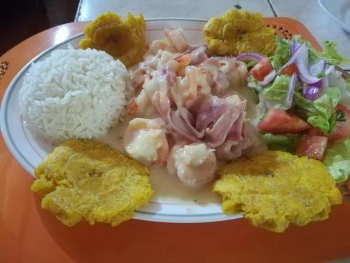 a plate of food with rice and a salad at Hosteria Cumilinche in Same