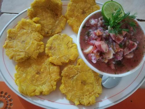 a plate of food with chips and a bowl of salsa at Hosteria Cumilinche in Same