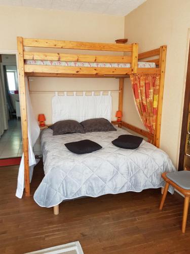 コンカルノーにあるLe petit Courcyのベッドルーム1室(木製ベッドフレーム付きのベッド1台付)