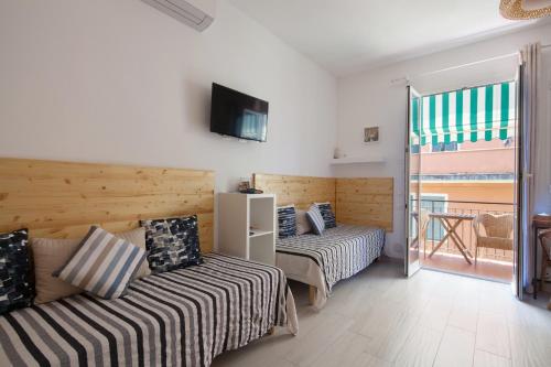 a hotel room with two beds and a balcony at Sciuscettùa 5 Terre in Monterosso al Mare