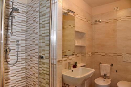 La salle de bains est pourvue d'un lavabo et d'une douche. dans l'établissement Albergo La Rosetta, à Chiusi