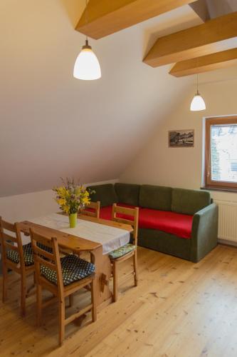 een woonkamer met een groene bank en een tafel bij Alpine Spot in Kranjska Gora