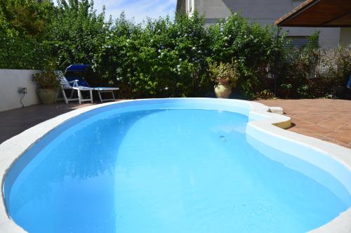 a large blue swimming pool in a backyard at B&B Villa Elisa in Bosa