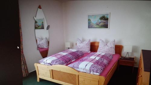 a bedroom with a bed with pink sheets and pillows at Ferienwohnung Berger in Bad Bergzabern