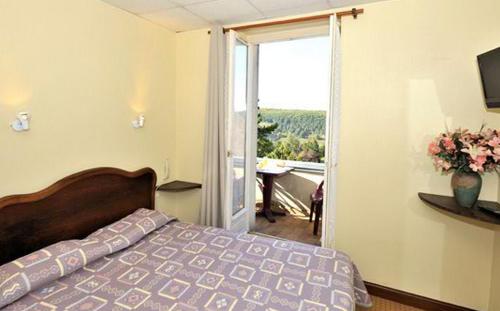 sypialnia z łóżkiem i przesuwnymi szklanymi drzwiami w obiekcie Le Compostelle w mieście Vézelay