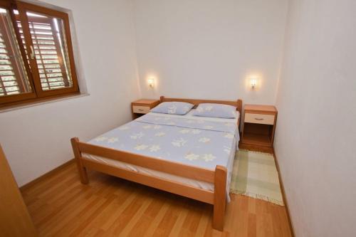 a bedroom with a bed and two tables and a window at Apartments Elia in Mandre
