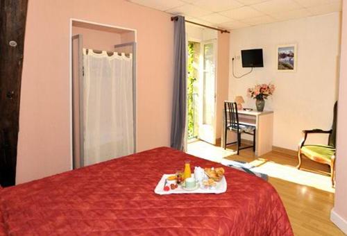 a room with a bed with a tray of food on it at Le Compostelle in Vézelay