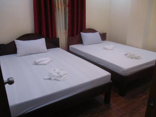 two beds in a room with towels on them at WMV Hotel & Restaurant in Infanta
