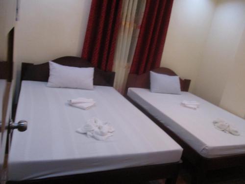 two beds in a room with towels on them at WMV Hotel & Restaurant in Infanta