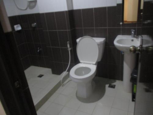 a bathroom with a toilet and a sink at WMV Hotel & Restaurant in Infanta